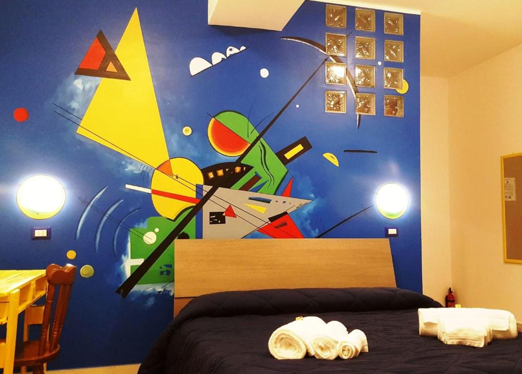 1 dormitorio con 1 cama con una pintura en la pared en La Dimora Degli Artisti, en Catanzaro