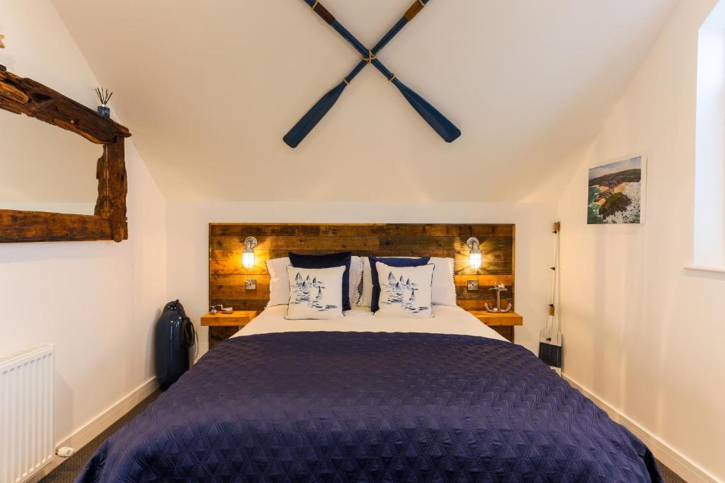 a bedroom with a large bed with a large clock on the wall at The Lighthouse Penthouse, Studio and Holiday Home in St Ives