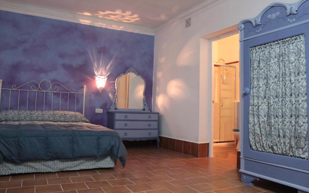 a bedroom with a bed and a dresser and a mirror at Casa Rural La Alfarera in Corral de Calatrava