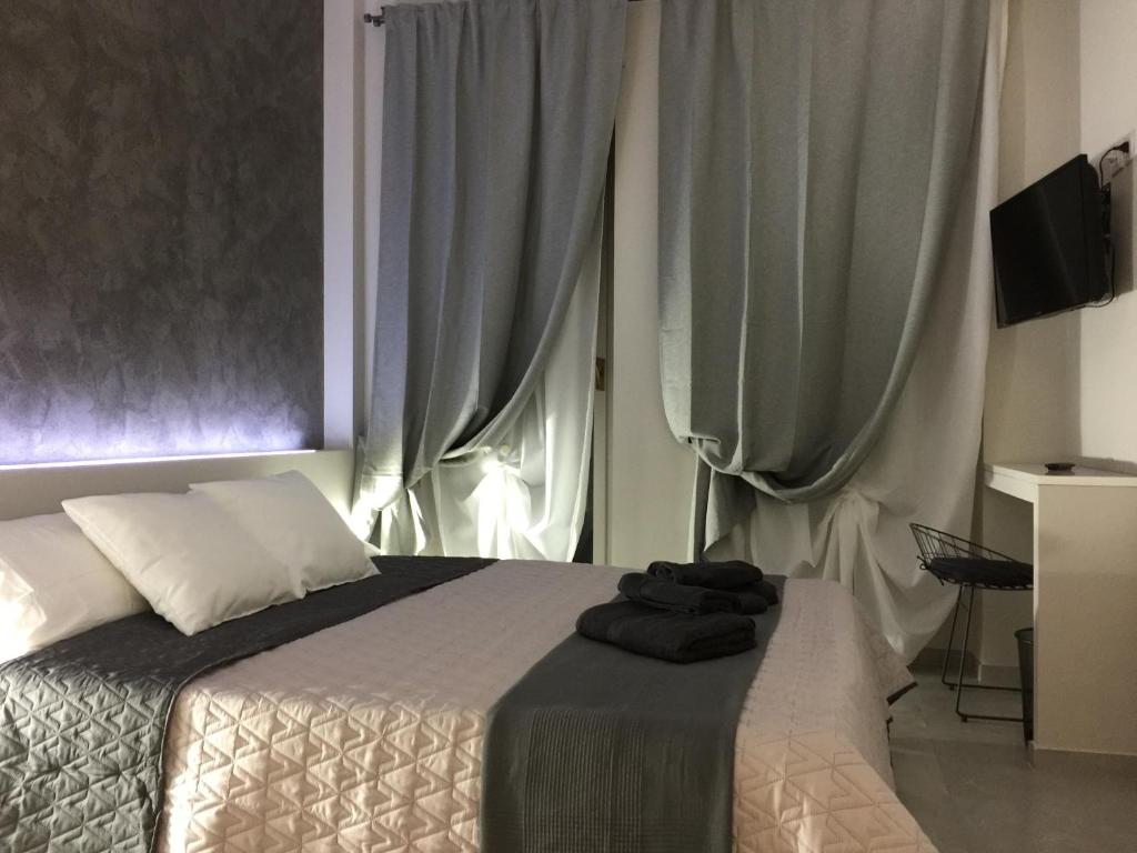 1 dormitorio con 1 cama y una ventana con cortinas en Turin Central Rooms en Turín