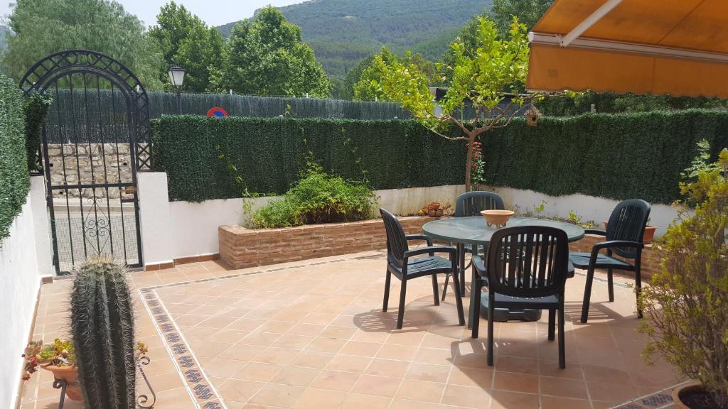 a patio with a table and chairs and a fence at CASA HACIENDA EL OLIVAR in El Bosque