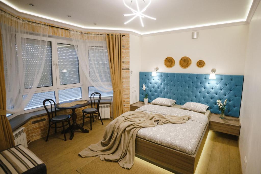 1 dormitorio con 1 cama, mesa y sillas en VIP Studio on E. Polotskoy 5 en Minsk
