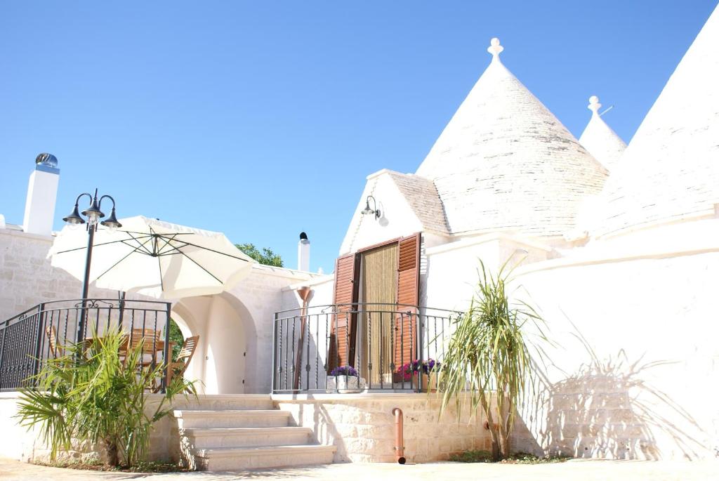 una casa bianca con scale e piante di fronte di Il Calàscione Apulian Villas a Locorotondo