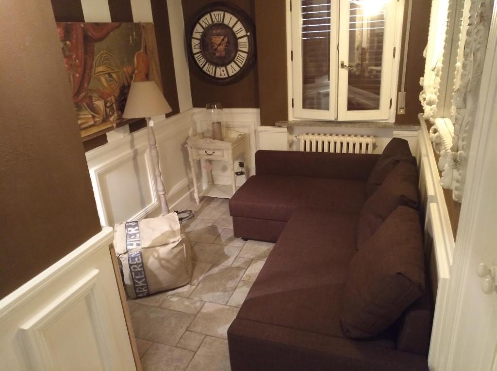 ein Wohnzimmer mit einem Sofa und einer Uhr an der Wand in der Unterkunft sweet home in Biella