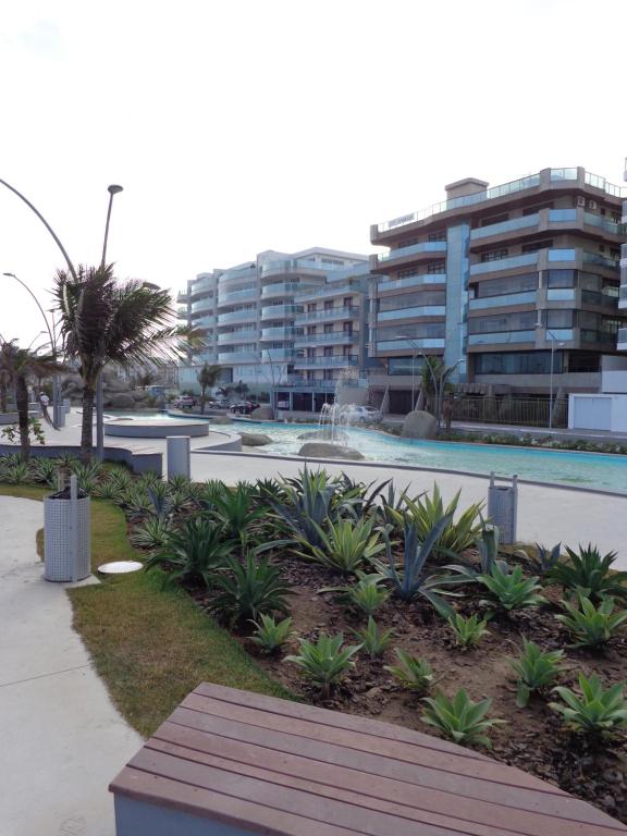 un parque con un banco frente a un edificio en Edifício Porto Real, en Cabo Frío