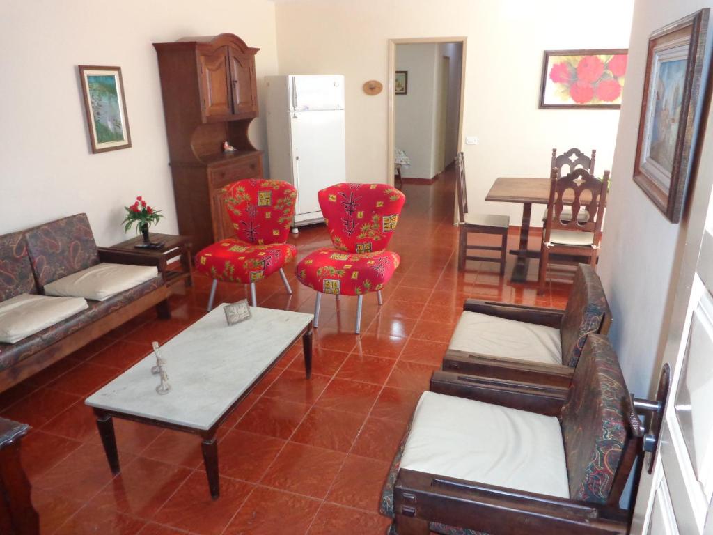 ein Wohnzimmer mit einem Sofa, Stühlen und einem Tisch in der Unterkunft Apto a 2 quadras da praia in Cabo Frio