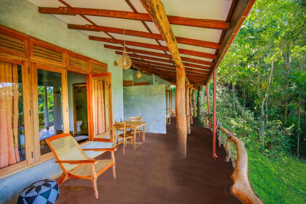 un porche de una casa con sillas y mesas en The Spice Lodge en Ella