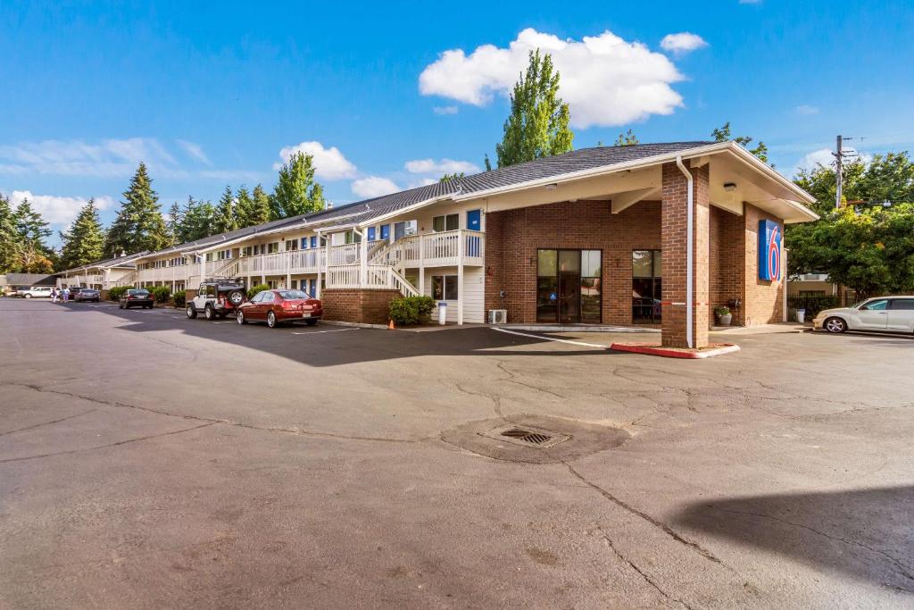 a hotel building with cars parked in a parking lot at Motel 6-Vancouver, WA in Vancouver