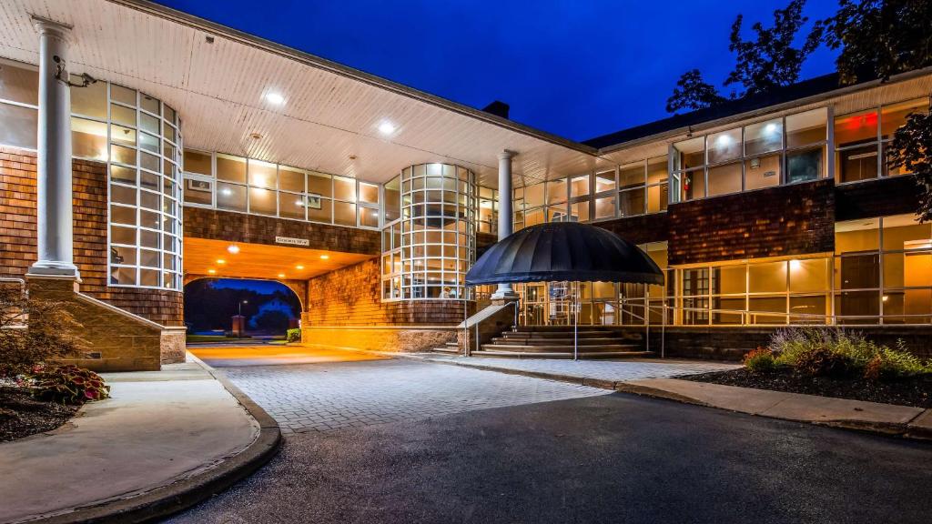 a building with a black umbrella in front of it at Best Western Plus The Inn & Suites at the Falls in Poughkeepsie