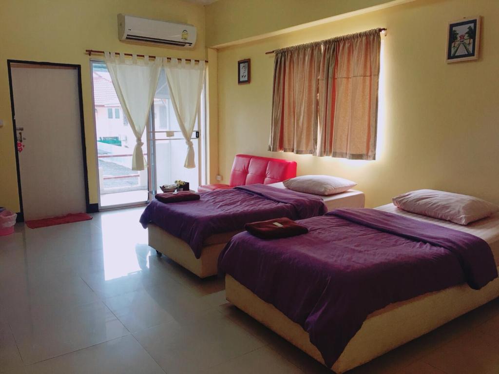 1 dormitorio con 2 camas y ventana en Peamsuk Sweet Prachin Buri en Prachin Buri
