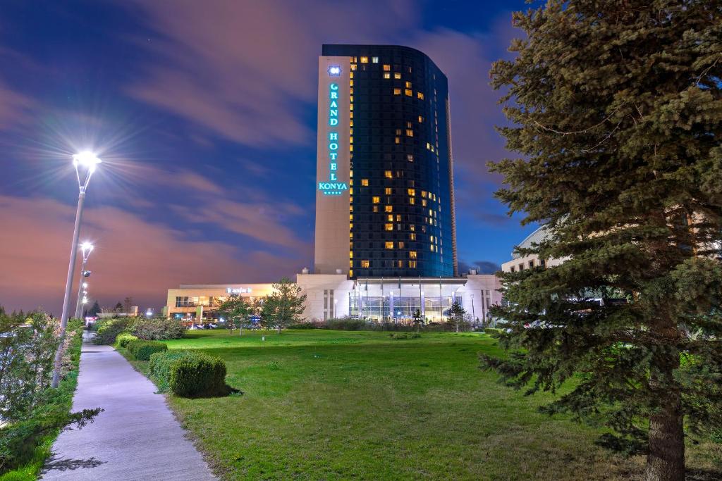 a tall building at night with a park at Grand Hotel Konya in Konya