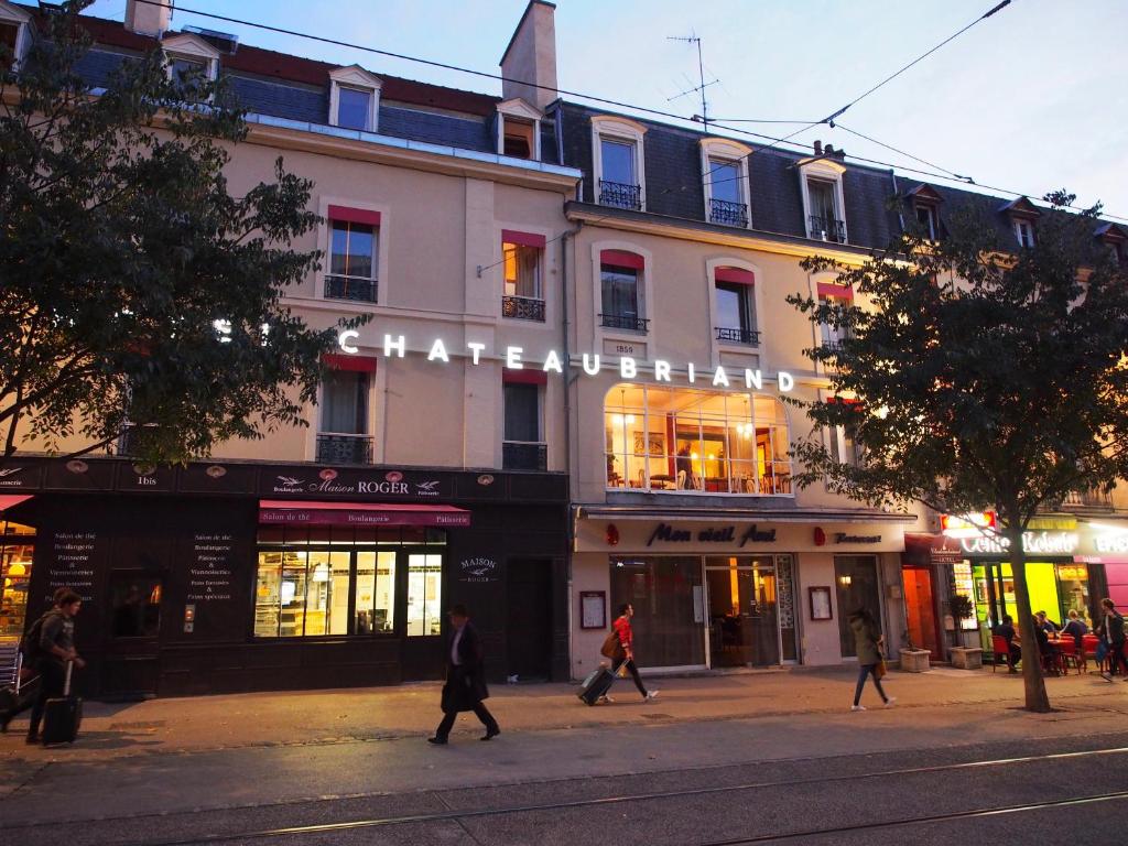 a building on a street with people walking in front of it at Hôtel Chateaubriand in Dijon