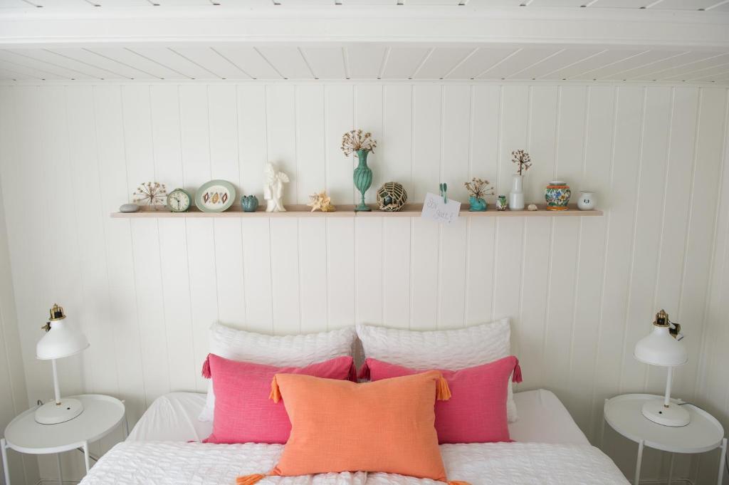 a bedroom with a bed with pink and white pillows at Olsens Pensjonat in Veiholmen