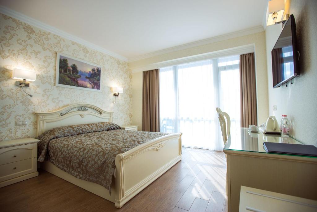 1 dormitorio con cama y ventana grande en Hotel El Paraiso, en Adler