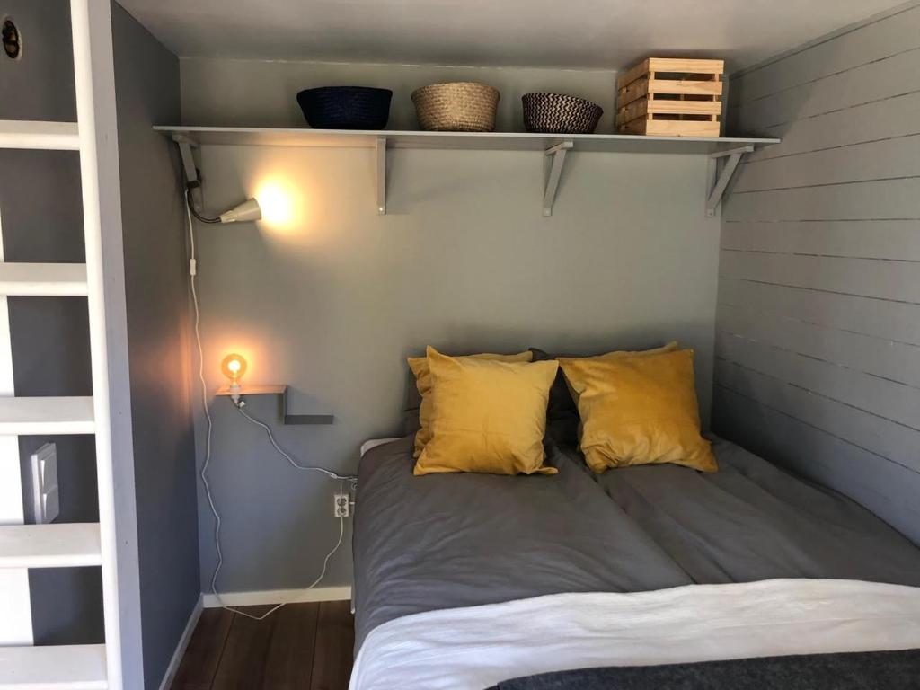 uma cama com duas almofadas amarelas num quarto em Lakeview Studio em Stavsjo