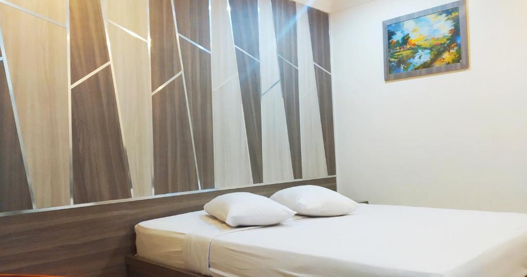 a bedroom with two beds and a painting on the wall at Paradise Hotel in Tanjung Pinang