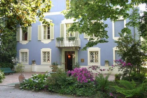 um edifício azul com uma varanda e flores em frente em Resort Dei Limoni em Lucca