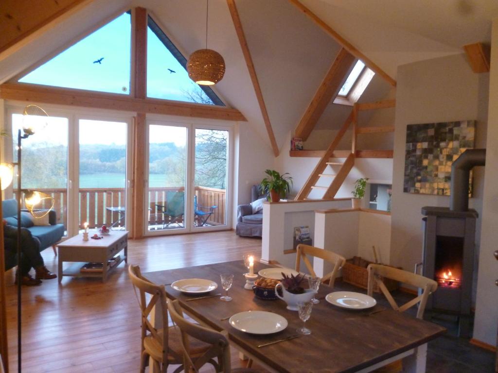 ein Esszimmer und ein Wohnzimmer mit einem großen Fenster in der Unterkunft BelEtage Eifel in Anschau