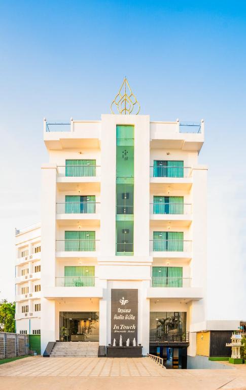 a white building with a sign in front of it at Intouch Riverside Hotel in Pakse