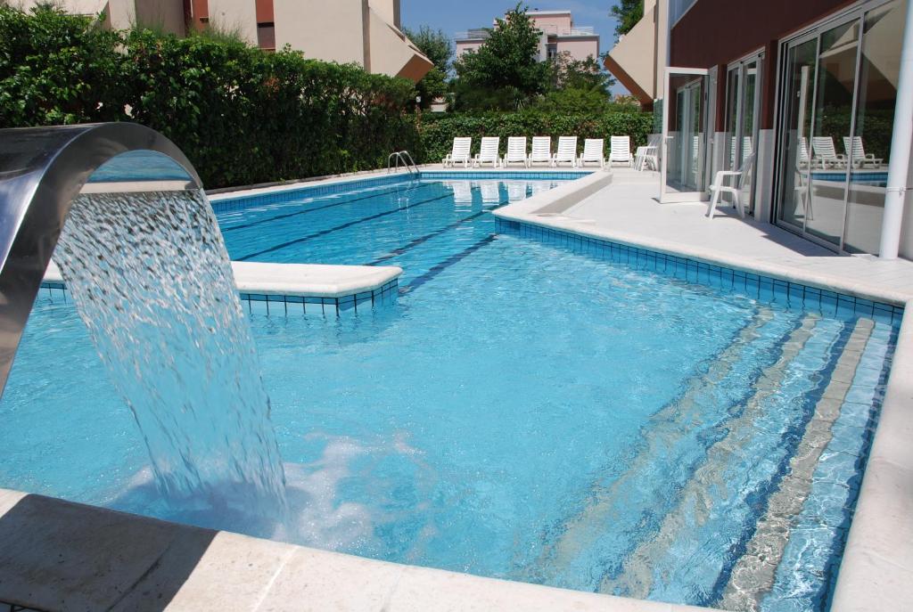 uma piscina com escorrega num edifício em Noha Suite Hotel em Riccione