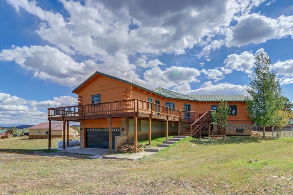 a large house with a deck on a field at Snow Circle Lodge in Pagosa Springs