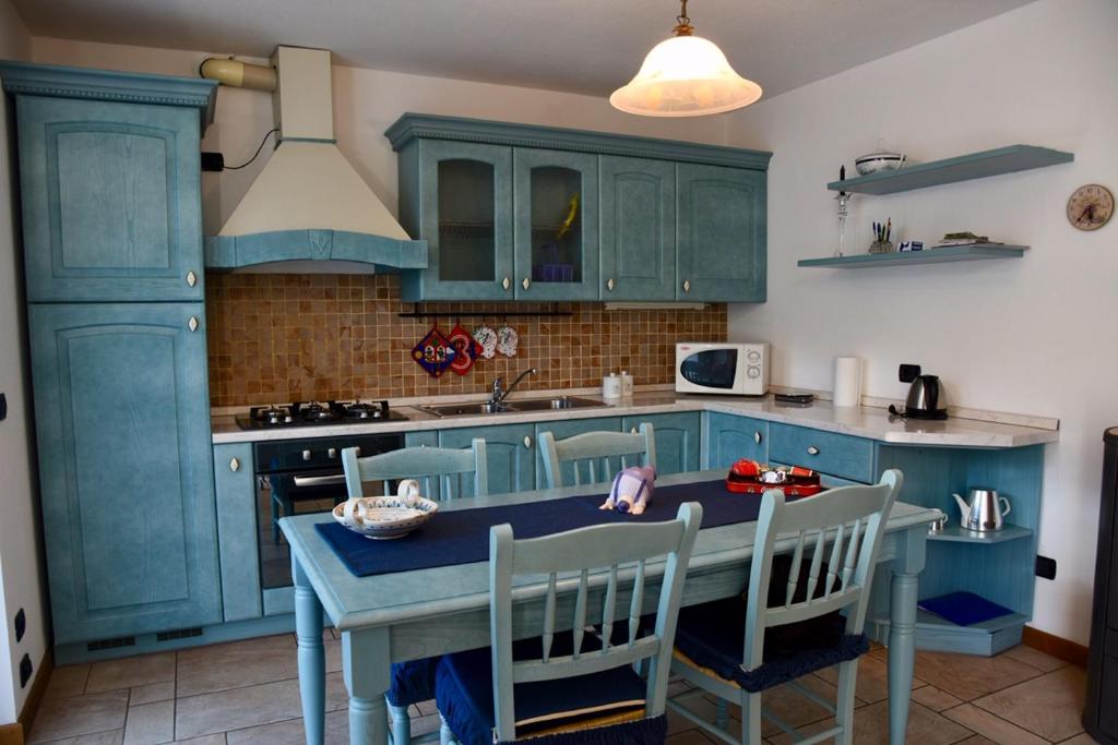 una cocina con armarios azules y una mesa con sillas en Baitin Finferlo en Valdidentro