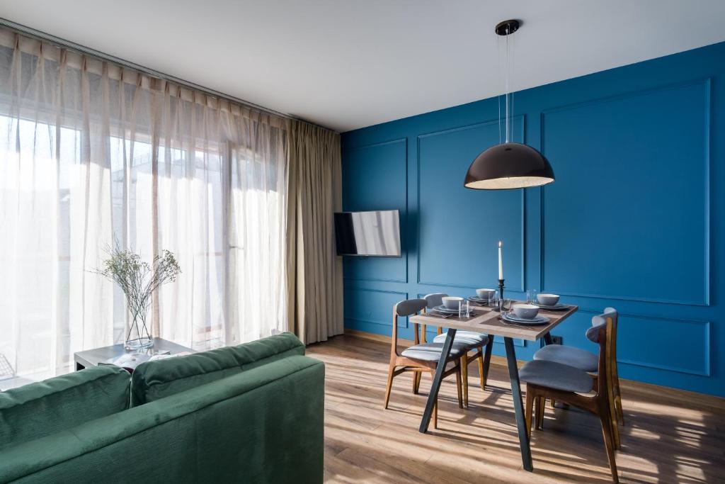 a living room with a green couch and a table at Elite Apartments Oliwa Martinique in Gdańsk