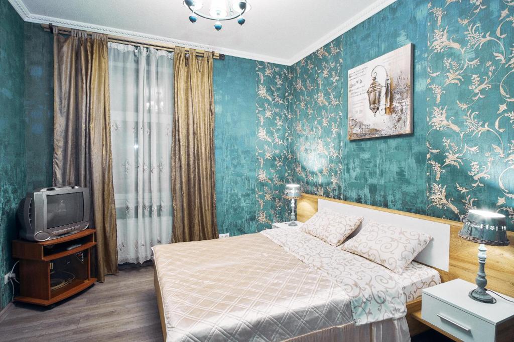een slaapkamer met een bed en een televisie bij Apartment on Lyul'ky 5 in Lviv