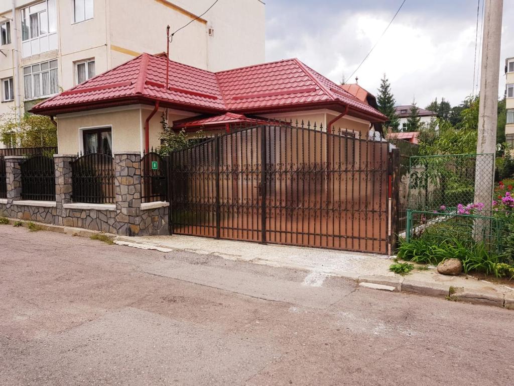 une maison avec un portail et un toit rouge dans l'établissement Casa Bunicii Sinaia, à Sinaia