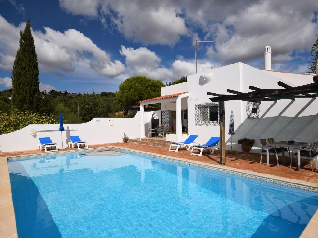 una piscina con sillas y una casa en Secluded villa with a private swimming pool, en Santa Bárbara de Nexe