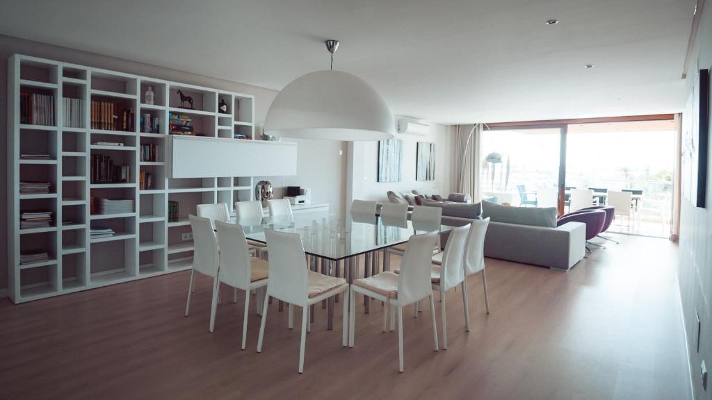 uma sala de jantar e sala de estar com mesa e cadeiras em Luxury sea view Apartment in Puerto de Alcudia em Alcudia