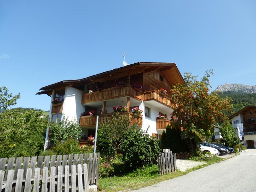 a house with a fence in front of it at Ciasa Isidor in San Vigilio Di Marebbe