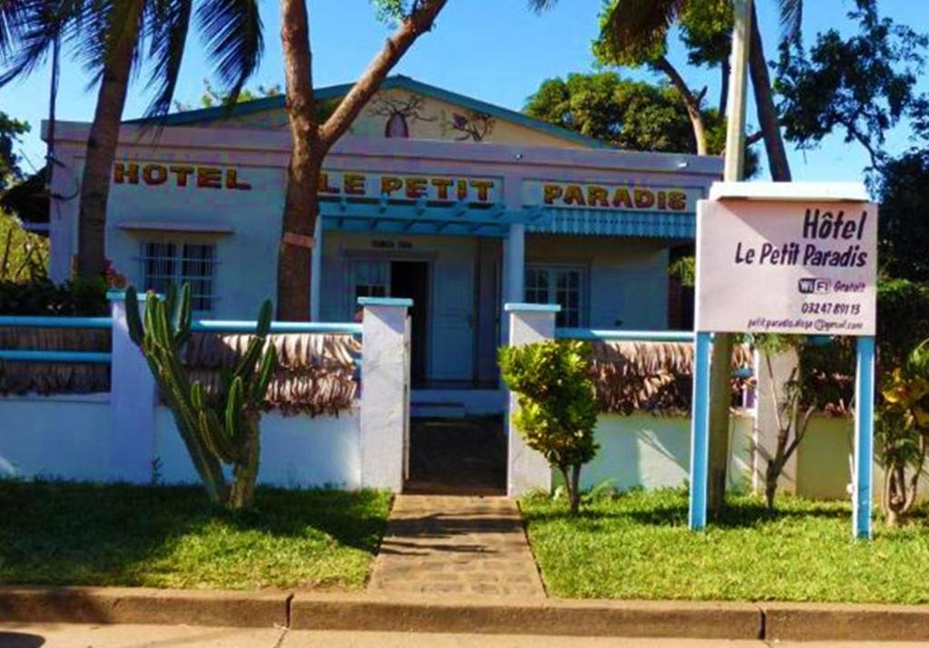 a hotel with a sign in front of a building at Hotel Le Petit Paradis in Diego Suarez