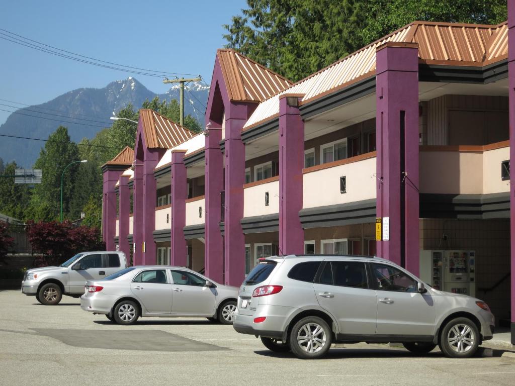 um grupo de carros estacionados em frente a um edifício em North Vancouver Hotel em North Vancouver