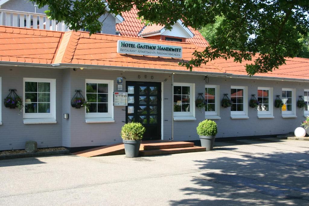 een gebouw met een bord met de hoofdingang bij Hotel Gasthof Handewitt in Handewitt