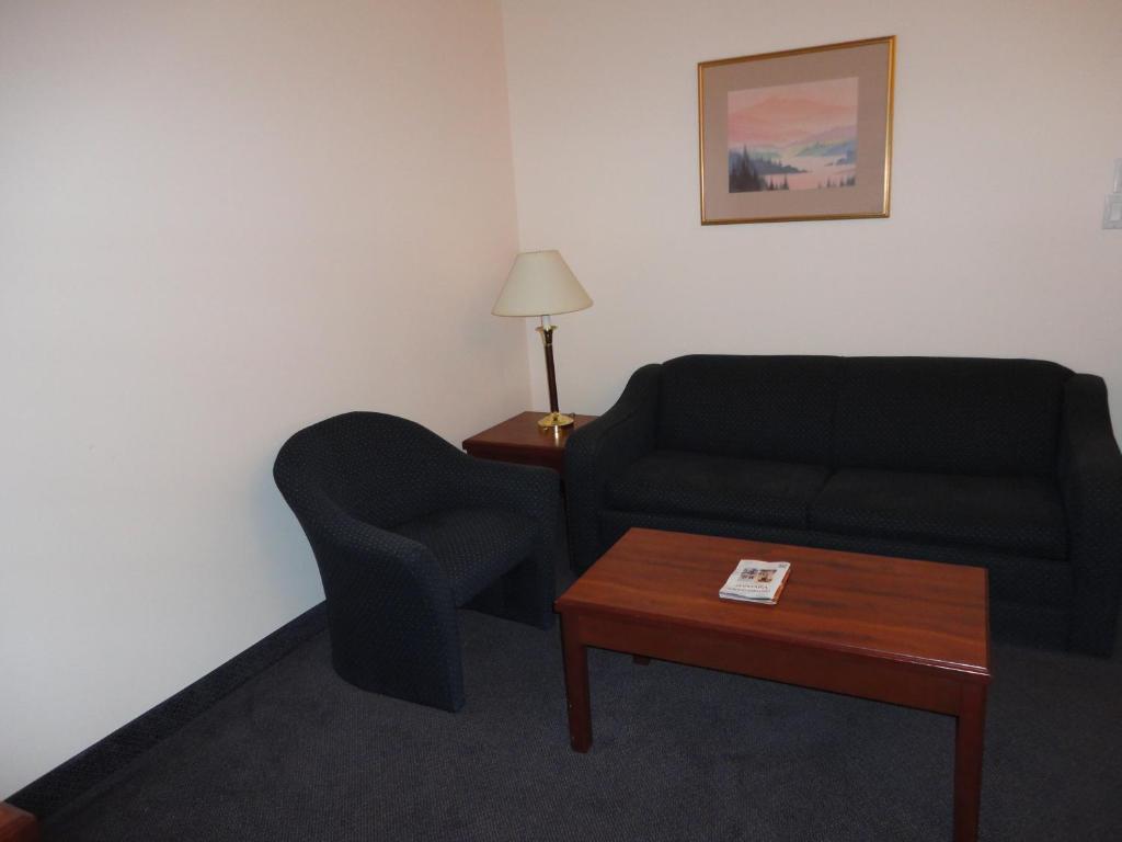 a living room with a couch and a chair at Rosedale on Robson Suite Hotel in Vancouver