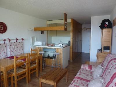 LES Herbelaines 133 في مانيجود: مطبخ وغرفة معيشة مع طاولة وكراسي