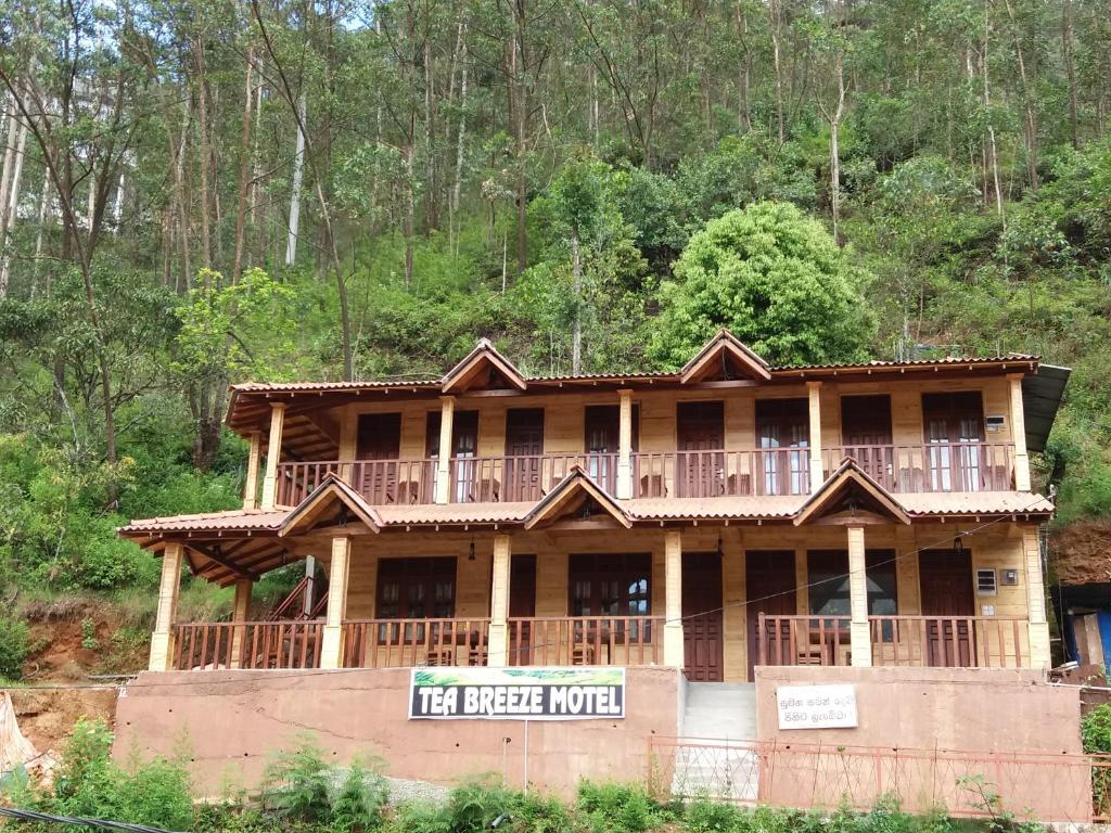 a large wooden house with a balcony on top at Tea Breeze Motel in Adams Peak