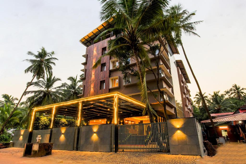 a building with palm trees in front of it at Rivasa Emerald - A Wellness Property in Calangute