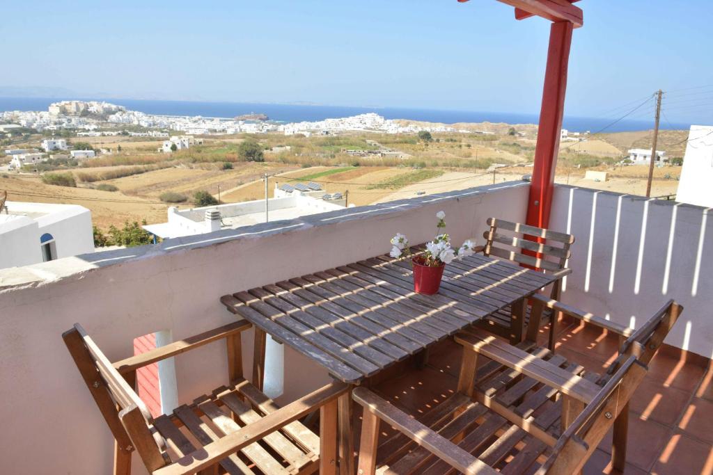 a wooden table and chairs on a balcony with the ocean at Paradisia Villas in Naxos Chora