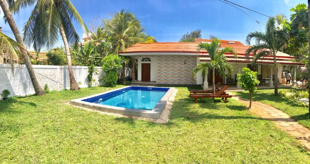 a house with a swimming pool in the yard at Ocean Gate Negombo in Negombo