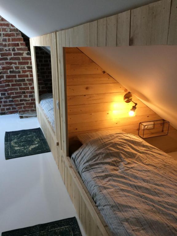 a bed in a wooden room with a roof at Nelly in Ypres