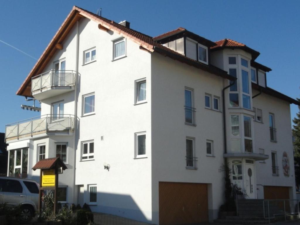 ein weißes Gebäude mit braunem Dach in der Unterkunft Haus Bodanblick in Bodman-Ludwigshafen