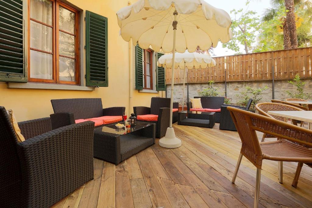 a patio with chairs and tables and a large umbrella at Relais Lavagnini Florence in Florence