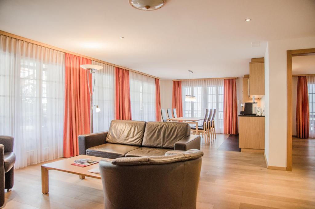 ein Wohnzimmer mit einem Sofa und einem Tisch in der Unterkunft Apartment Stotzhalten 3.5 - GriwaRent AG in Grindelwald