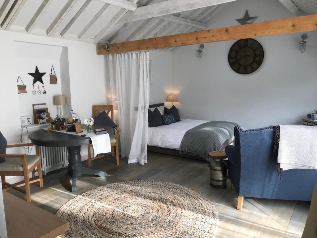 1 dormitorio con cama, escritorio y mesa en Crafts Hill Barn, en Cambridge