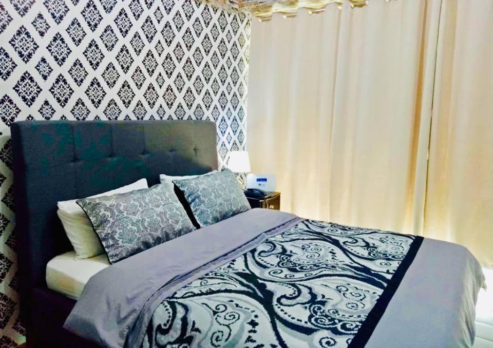 a bedroom with a bed with a blue and white comforter at Condo Unit walking distance to Manila Airport (NAIA Terminal 3) in Manila