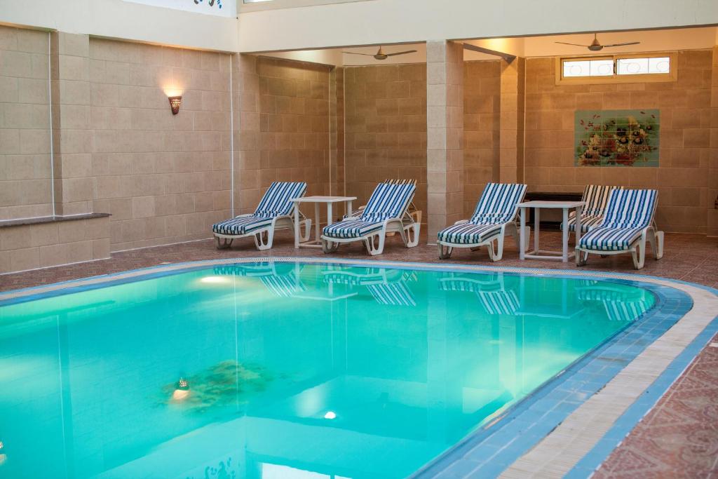 a pool in a hotel with chairs and a table at Ali Baba Safaga Hotel in Hurghada