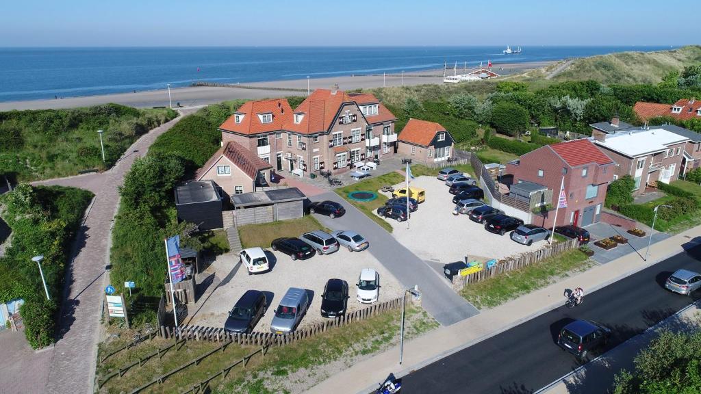 an aerial view of a house with cars parked in a parking lot at Duinhotel Haga in Zoutelande
