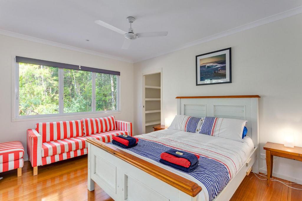 a bedroom with a bed and a couch at Sandyfeet House in Rainbow Beach